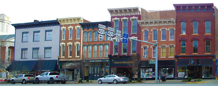 200 Block of East Main Street view Madison Indiana. Fine Threads clothing store. Village Peddler antique shop and trade. Golde-n-Treasures variety antique shop. Fabric Shop Embroidery and in store loom made rugs. JoeyG’s nightclub, bar, and live stage performances.
